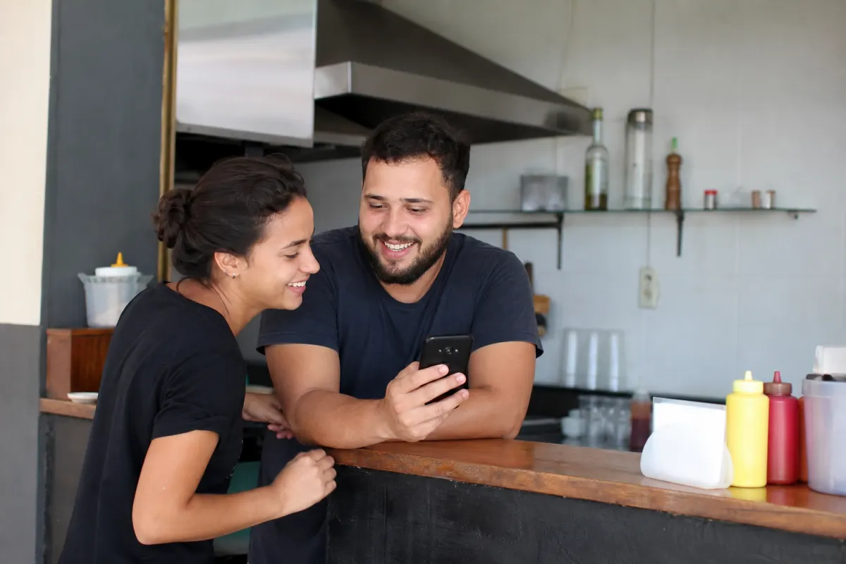 Foto ilustrativa: empreendedor mostrando o Instagram da loja no celular