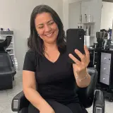 Dona de salão de beleza mostrando o celular