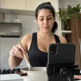 Moça filmando uma receita na cozinha