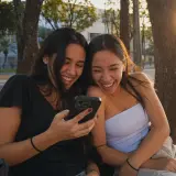 Amigas lendo comentários no celular